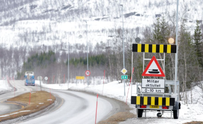 Bilde av et fare for militær aktivitet-skilt ved en vei