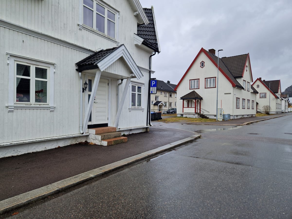 Bilde av et vegkryss med et parkeringsskilt rett ved vegkrysset