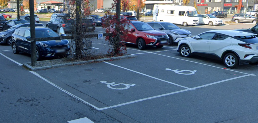 Bilde av et parkeringsfelt med handicapmarkering.